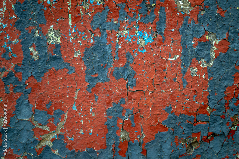 Blue and red paint on old concrete wall. Weathered wall with chipped paint. Cracked texture, abstract background.