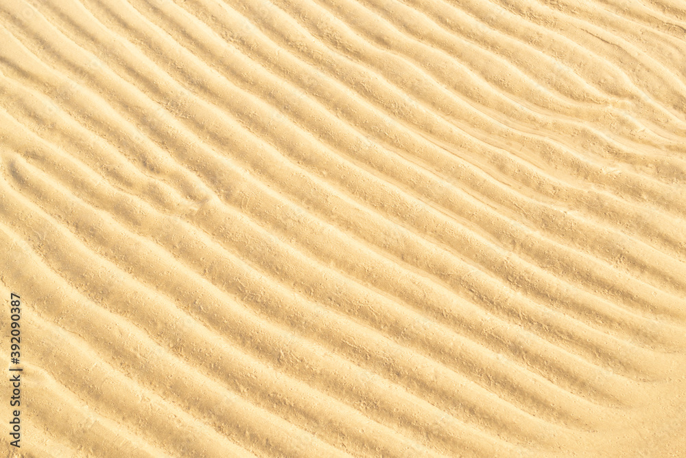Gold sand texture background. Summer and holiday concept. Sea shore with wavy sand close-up. Top view, copy space. Gold sand texture background. Summer and holiday concept. Sea shore with wavy sand close-up. Top view, copy space.