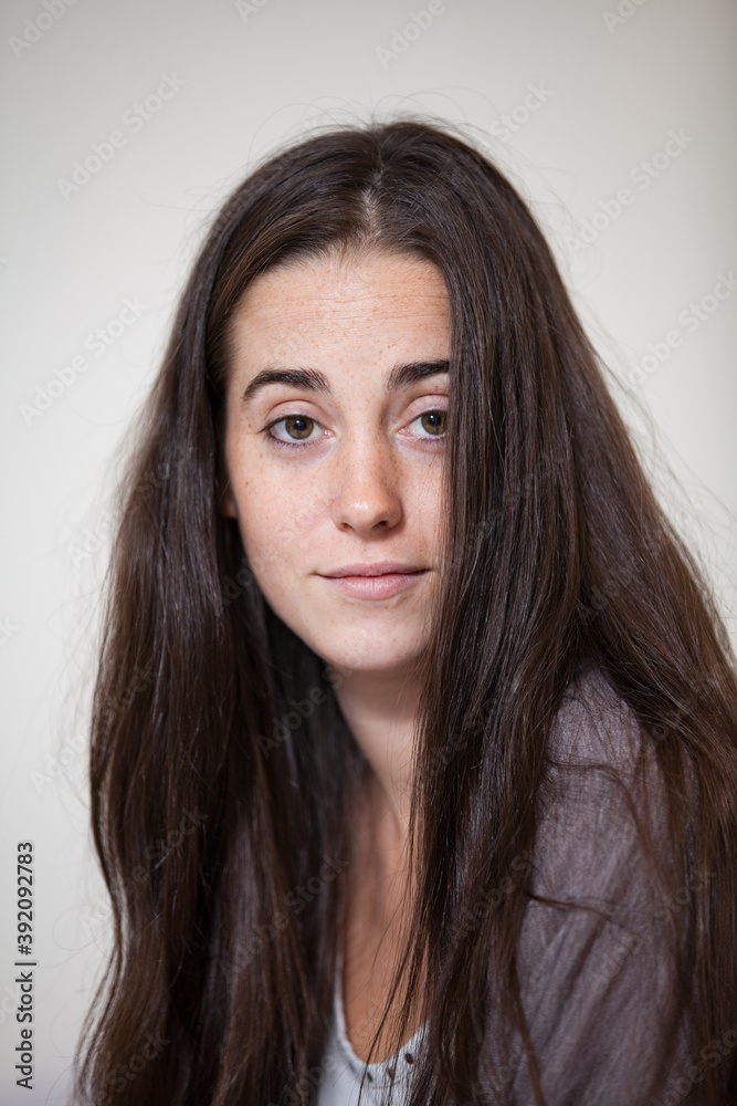 Portrait of a young and sweet natural woman without makeup with long brown hair Portrait of a young and sweet natural woman without makeup with long brown hair