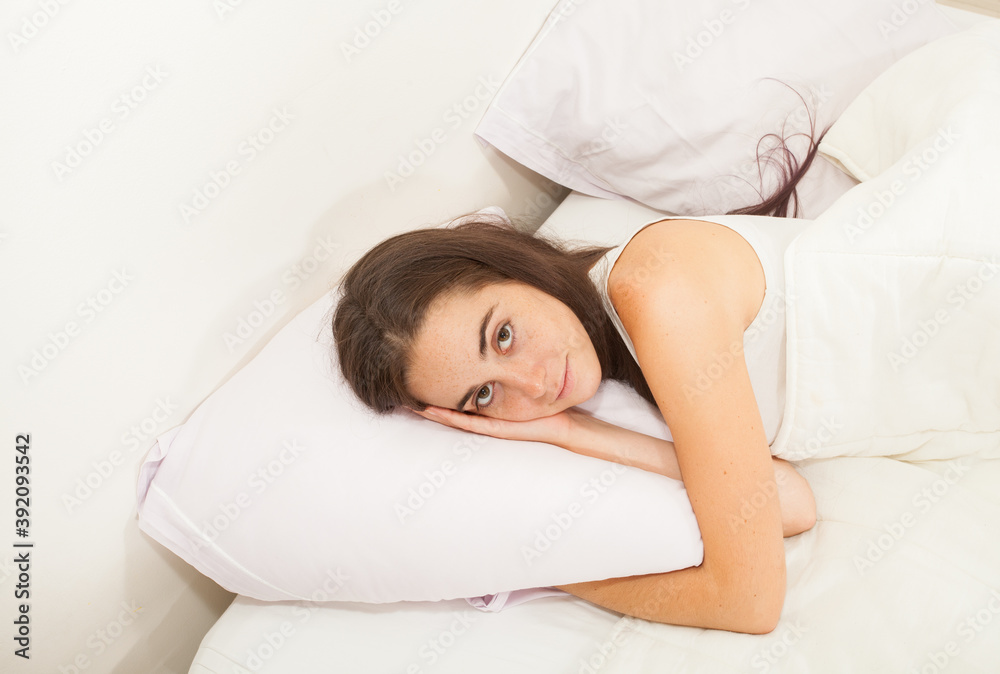 Portrait of a young attractive woman with long hair sleeping in her bed
