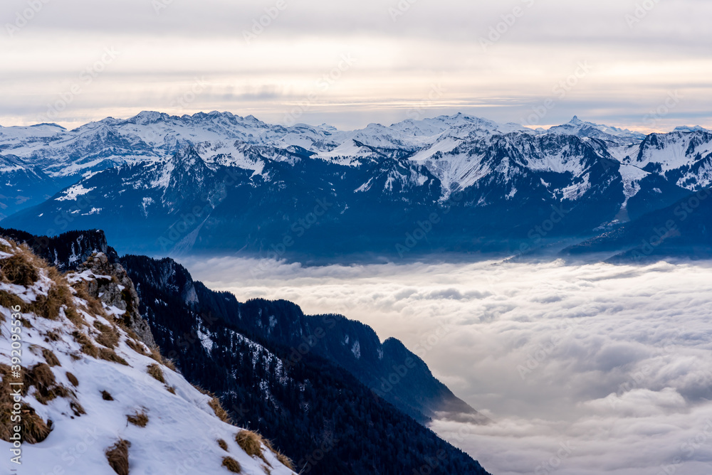 Alpine landscape with peaks covered by snow and clouds. Rochers de Naye, Switzerland.
