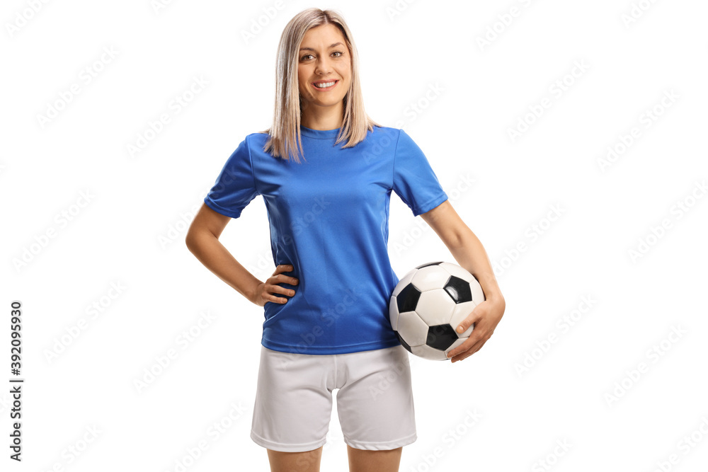 Female soccer player smiling and posing with a soccer ball under her arm - obrazy, fototapety, plakaty 