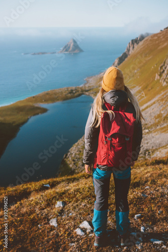 Woman traveling hiking with backpack looking at aerial ocean view in Norway solo trip outdoor healthy lifestyle weekend getaway