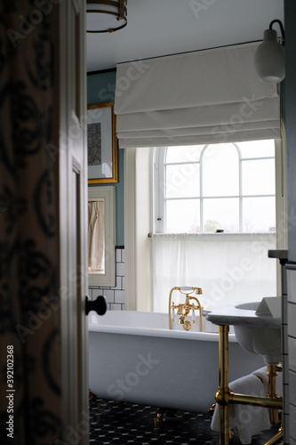 Light and beautiful retro bathroom with vintage bathtub and golden tap