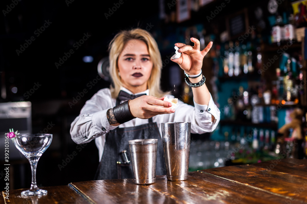 Girl barman concocts a cocktail in the public house
