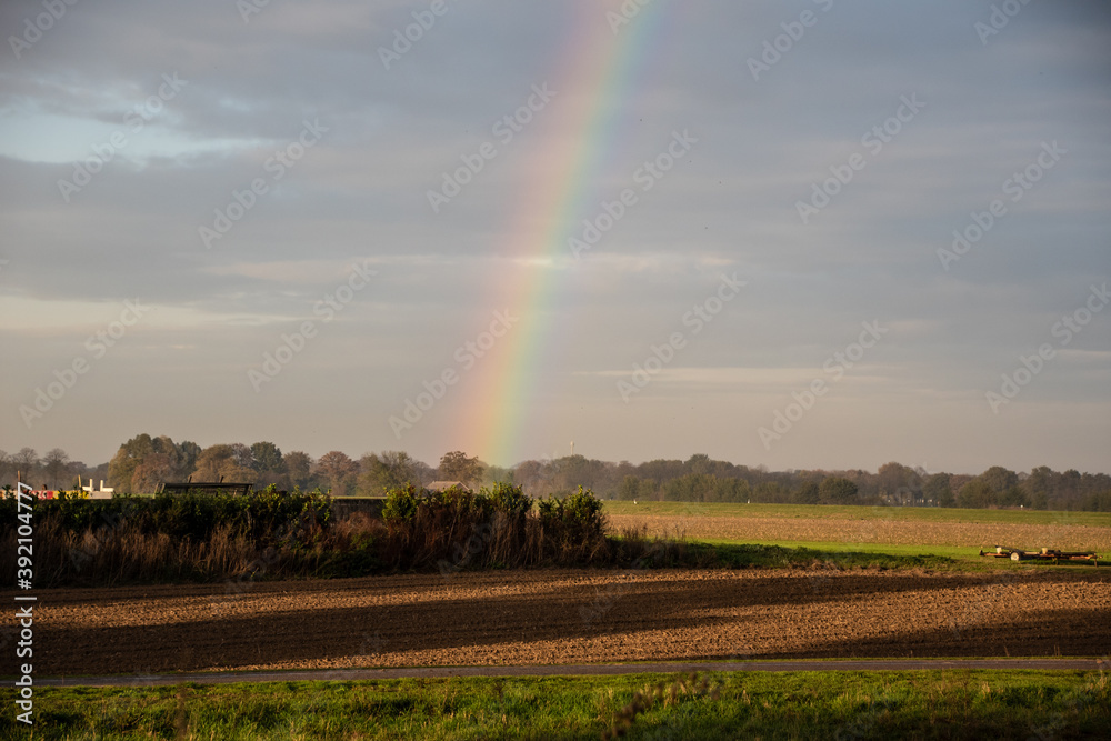 Rainbow over stormy sky. Rural landscape with rainbow over dark stormy sky in a countryside at autumn day Rainbow over stormy sky. Rural landscape with rainbow over dark stormy sky in a countryside at autumn day