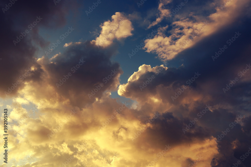 Blue and yellow cloudscape for an epic and dramatic dark wallpaper - artistic texture effect during a sunset Blue and yellow cloudscape for an epic and dramatic dark wallpaper - artistic texture effect during a sunset