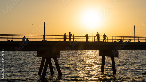 Pier with fishermen at sunset on Masirah Island in Oman