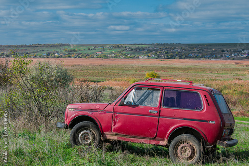 Red old car in nature. Rural landscape.