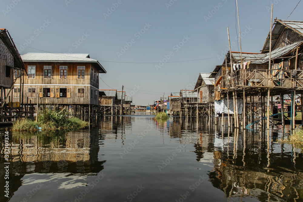 Floating village of Inle Lake is one of the most spectacular destinations and features of Myanmar.Rural lifestyle in Asia.Fishermen simple houses.People on boat. Traditional bamboo buildings.