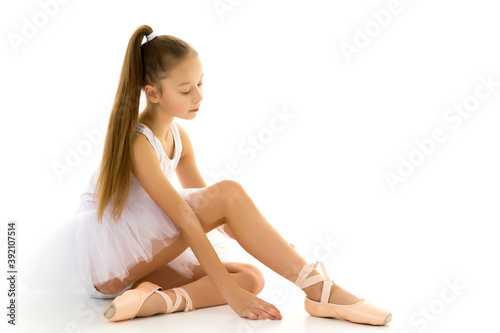 Girl ballerina puts on pointe shoes. The concept of dancing.
