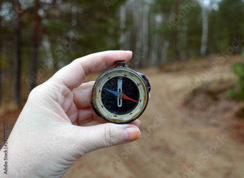 a woman's hand on the hunt holds a compass to determine the location