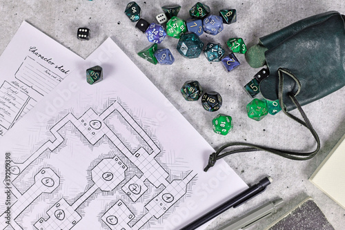 Tabletop role playing flat lay with RPG game dices, character sheet,dungeon map and pen on wooden desk photo