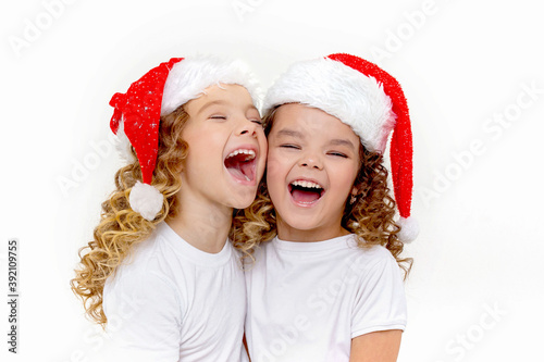 two laughing little girls in santa hats