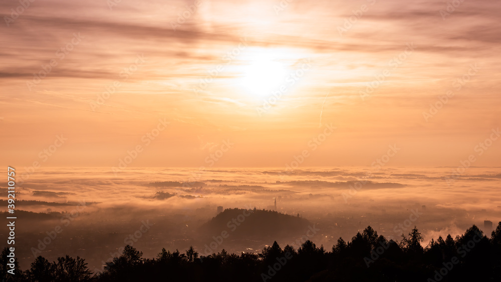 Panorama of Graz city in Styria on autumn morning during sunraise above fog