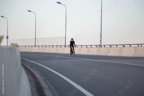 Woman training on a bicycle in the city at dawn. Yacht bridge St. Petersburg © Алексей Васильев