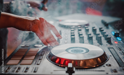 DJ Hands creating and regulating music on dj console mixer in concert nightclub stage