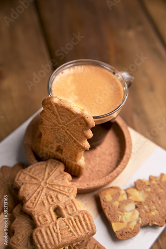 Nicolas day the background of festive garlands. Speculaas koekjes and espresso for st. Dutch holiday Sinterklaas traditional sweets gingerbread cookies. 5th December holiday in the Netherlands. 