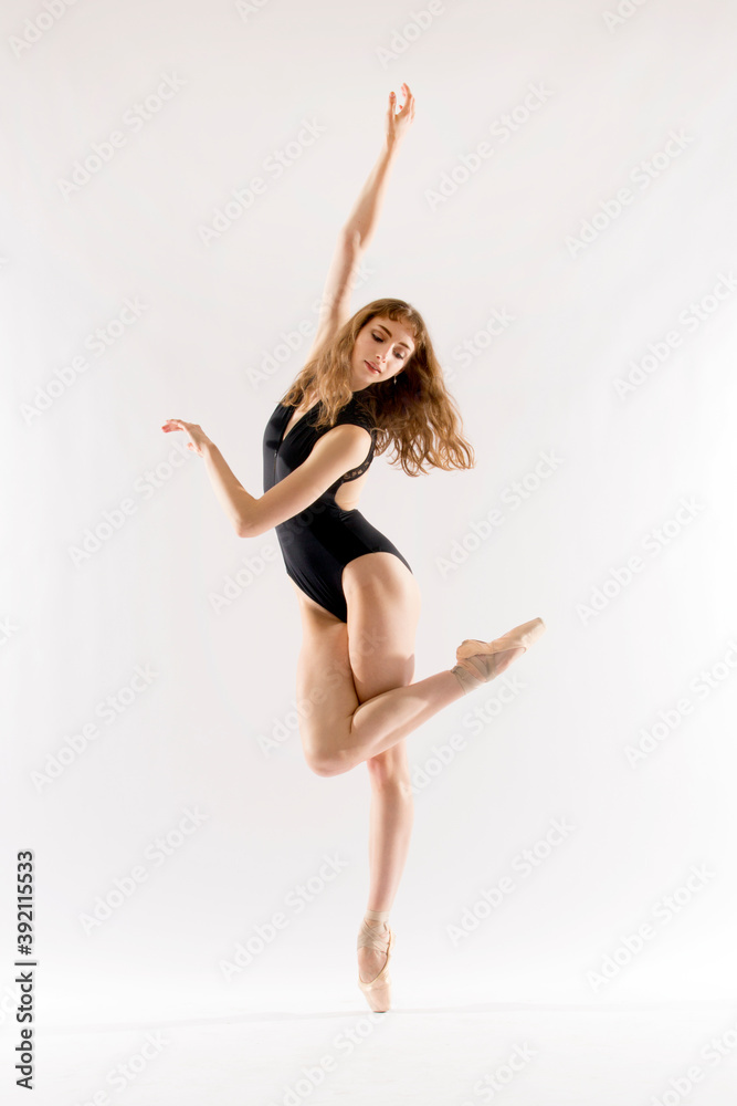 Ballerina in black leotard, dancing against a white background. Ballerina in black leotard, dancing against a white background.