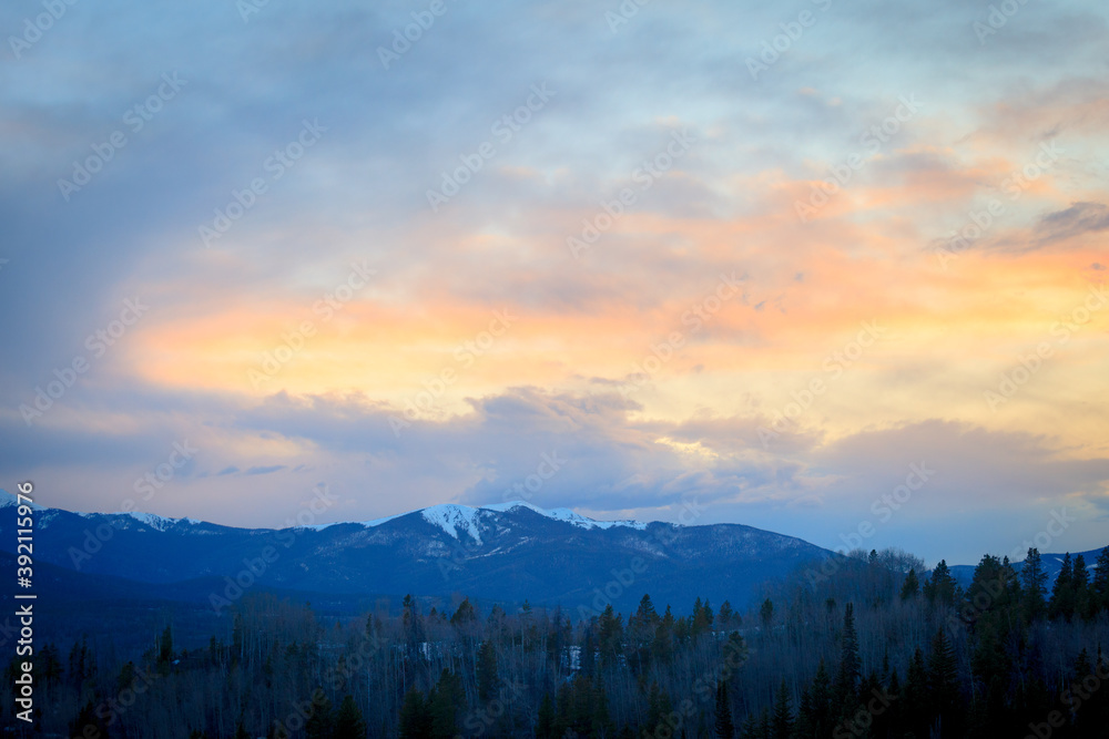 Snow capped mountain landscape at sunset near forest in Apraho National Forest, Colorado