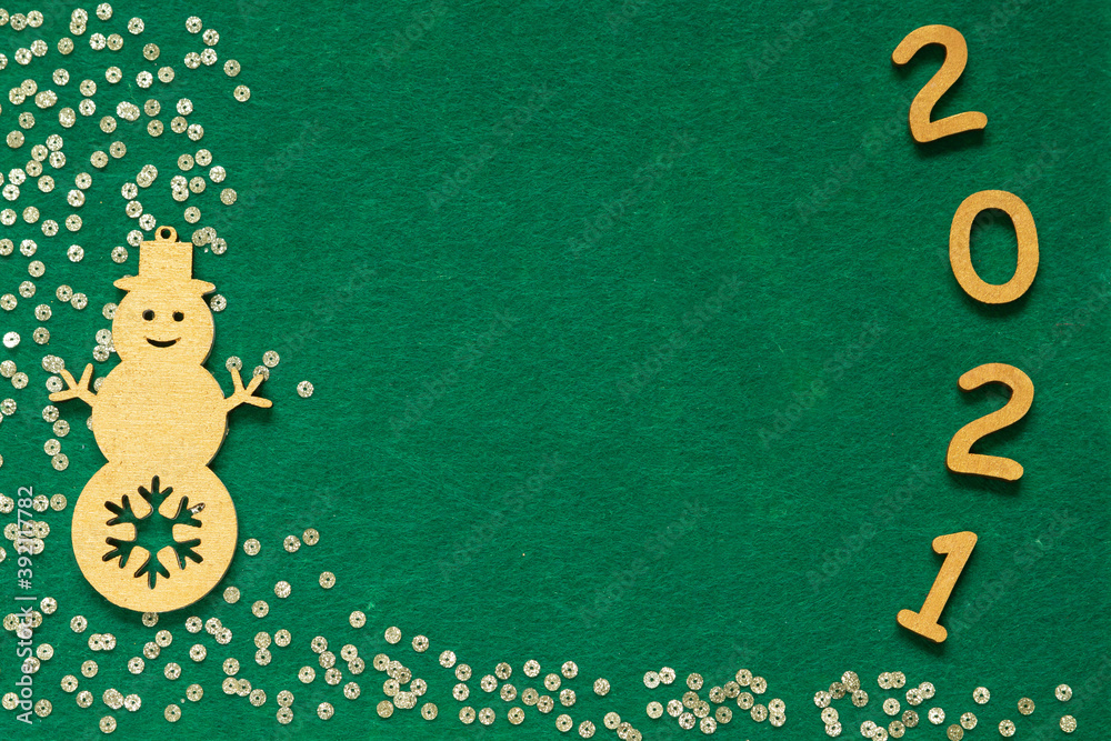 Fototapeta premium Happy New year 2021 celebration. Gold wooden numbers 2021 and gold confetti on green felt background. Flat lay with space for text