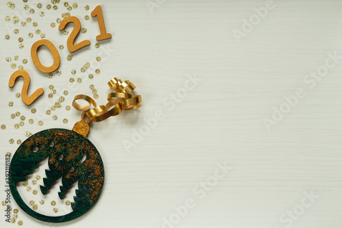 Happy New year 2021 celebration. Gold wooden numbers 2021 and gold confetti on light yellow background. Flat lay with space for text