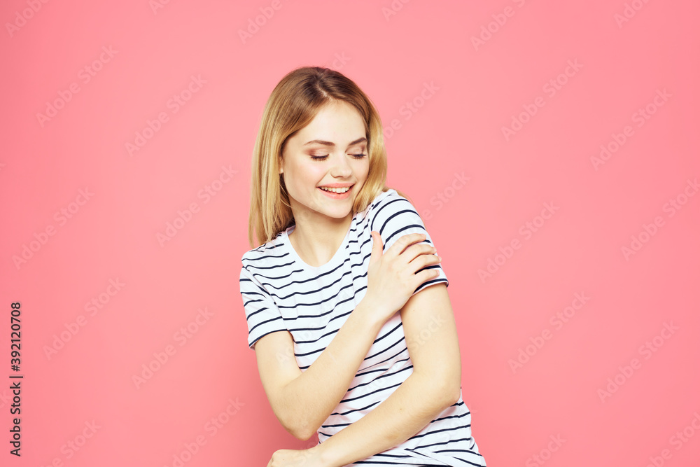 Cheerful woman striped t-shirt lifestyle emotions and gestures with hands pink background Cheerful woman striped t-shirt lifestyle emotions and gestures with hands pink background