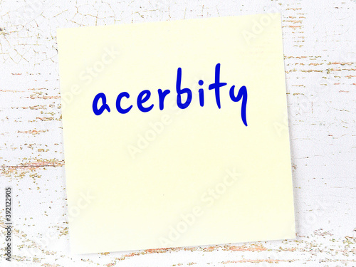 Fotografie Yellow sticky note on wooden wall with handwritten word acerbity