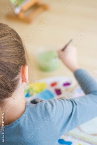 The child holding a paintbrush in the process of drawing