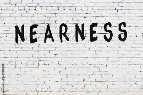 White wall with black paint inscription nearness on it