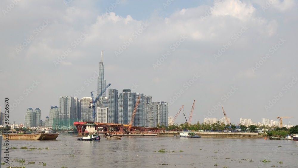 Obraz premium Landmark 81 the highest buildng in Vietnam. River in Ho Chi Minh City (Saigon) and Skyscrapers in the business district. View from the park. South-East Asia