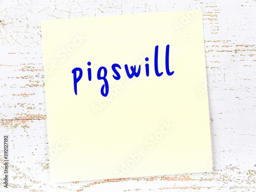 Yellow sheet of paper with word pigswill. Reminder concept photo