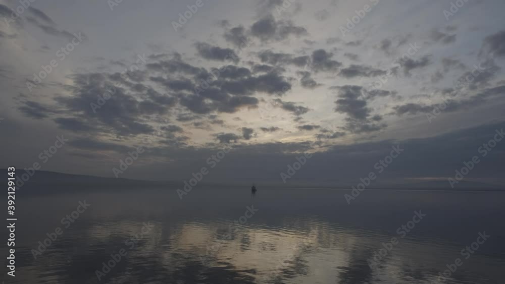 Over the quiet sea gulf clouds float. In the middle of the gulf there is a ship. Soft image. The accelerated video. There is a small movement and rocking of the camera. Over the quiet sea gulf clouds float. In the middle of the gulf there is a ship. Soft image. The accelerated video. There is a small movement and rocking of the camera.