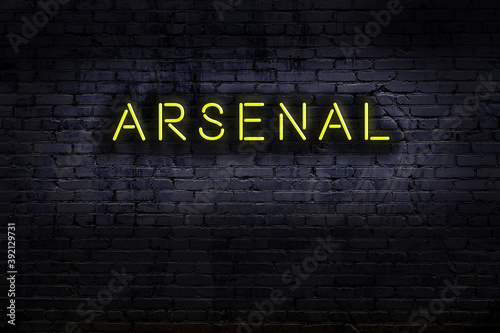 Night view of neon sign on brick wall with inscription arsenal photo