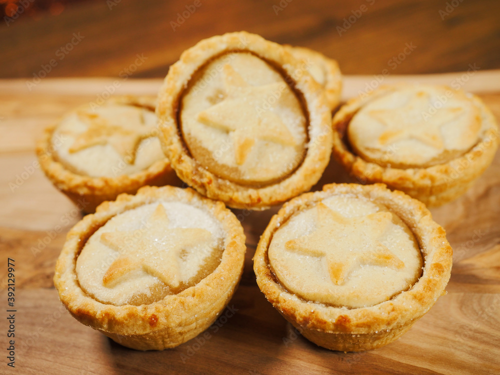 Fresh mince pies on a wooden board. Traditional Christmas pastry product.