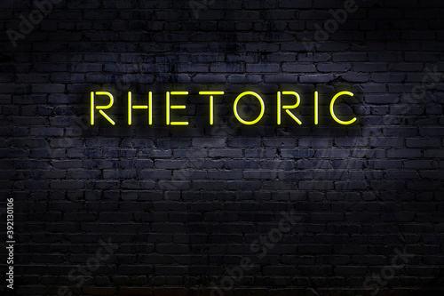 Night view of neon sign on brick wall with inscription rhetoric photo
