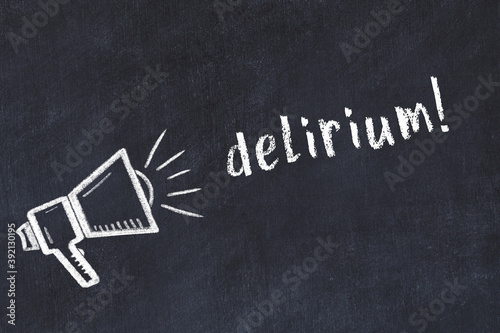 Chalk loudspeaker and inscription delirium on black chalkboard