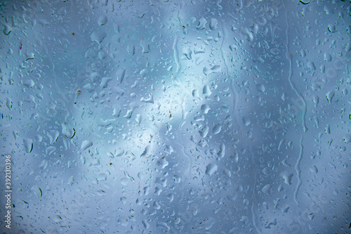 Raindrops on the glass and water runs down the glass, photography and background. Rain, water, nature and rainy weather, photo