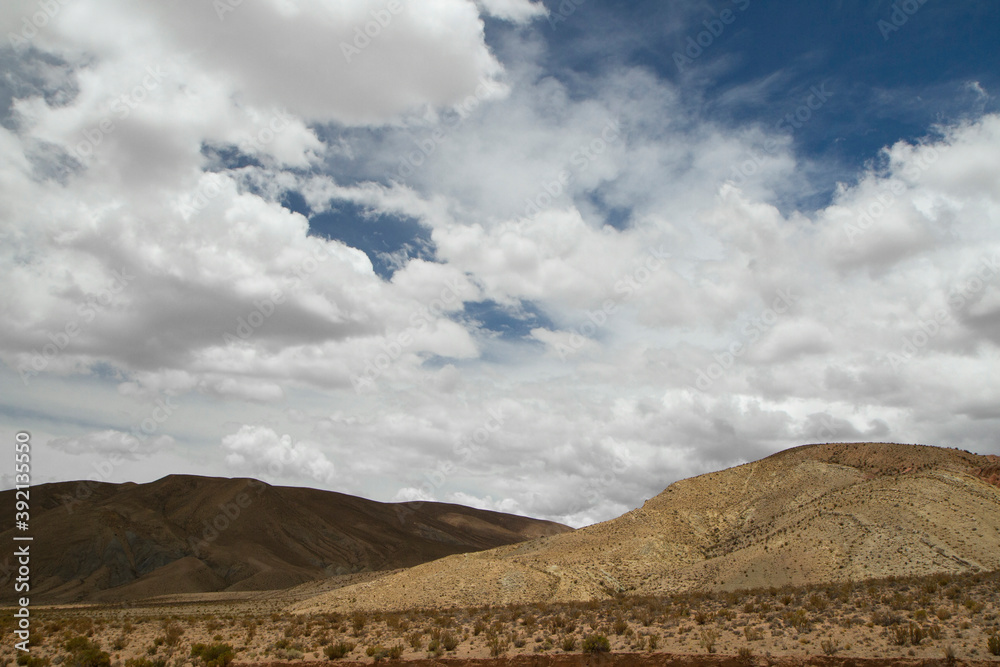Altiplano. Desert landscape. Majestic view of the arid valley and mountains under a dramatic cloudy sky. Altiplano. Desert landscape. Majestic view of the arid valley and mountains under a dramatic cloudy sky.