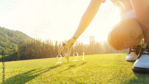 Golfer woman putting golf ball for Happy New Year 2021 on the green golf for new healthy. copy space. Healthy and Holiday Concept.