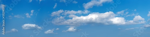 Ultra wide panorama of afternoon blue sky with white clouds.
