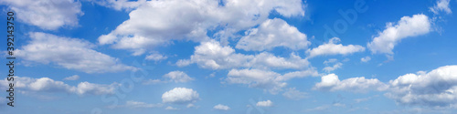 Ultra wide panorama of afternoon blue sky with white clouds.