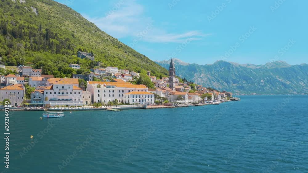Drone flying over the the St. Nicholas Church and cityscape in Perast, Montenegro. Amazing blue sea and magnificent mountains