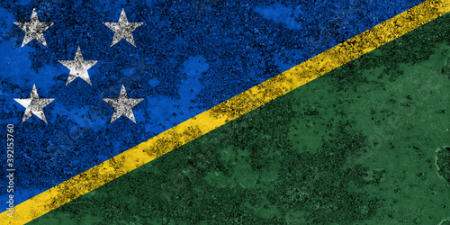 Flag of the Solomon Islands painted on the old grunge rustic iron surface. Abstract paint of the Solomon Islands national flag on the iron surface