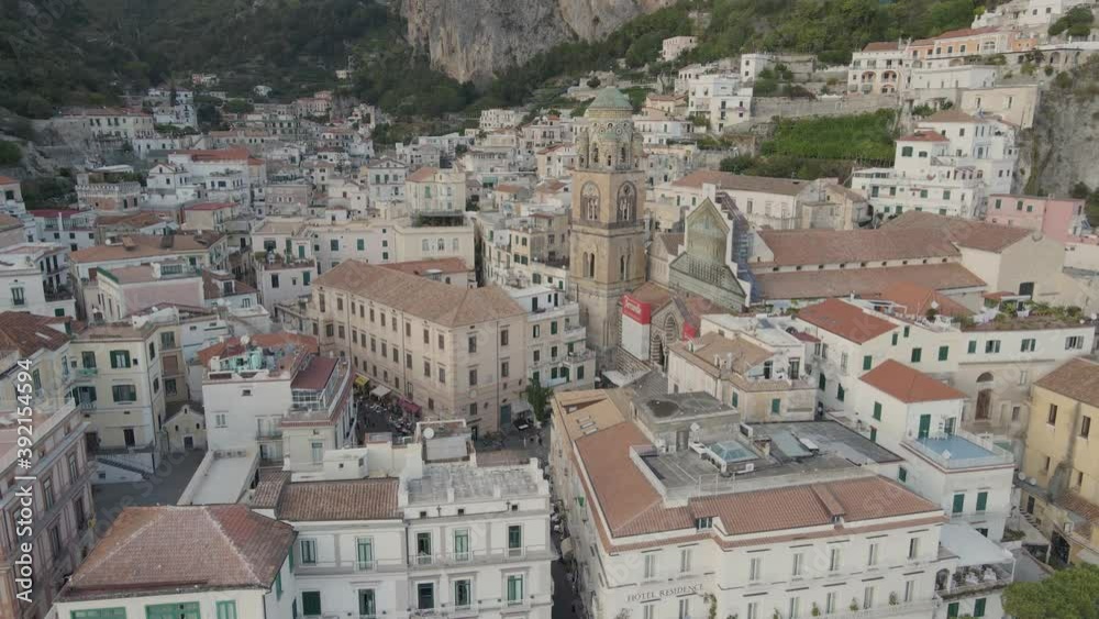 Amalfi Italy, aerial view of picturesque coastal old city on Mediterranean sea. Bell tower and houses under steep rocky cliffs, cityscape drone shot Amalfi Italy, aerial view of picturesque coastal old city on Mediterranean sea. Bell tower and houses under steep rocky cliffs, cityscape drone shot