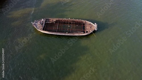 Close fly over white Egret birds stood fishing on old wooden boat wreck photo