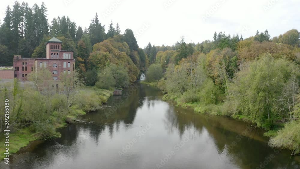 Drone flying over river towards waterfall with rustic brick building and fall colors - Tumwater Falls Olympia WA Drone flying over river towards waterfall with rustic brick building and fall colors - Tumwater Falls Olympia WA