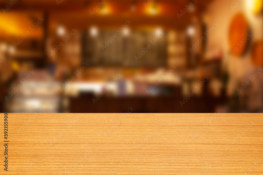 Empty wooden table and blur bar and cafe background with counter and light bokeh, restaurants. Ready for product montage display. template