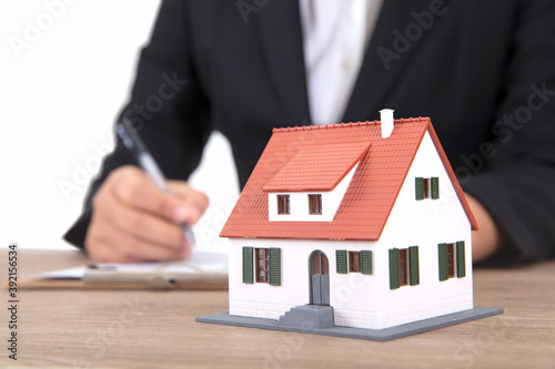 Real estate related practitioners working on a table with a small house model
