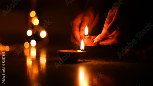 Traditional Divali indian festival, Women lighting diya, Diya closeup